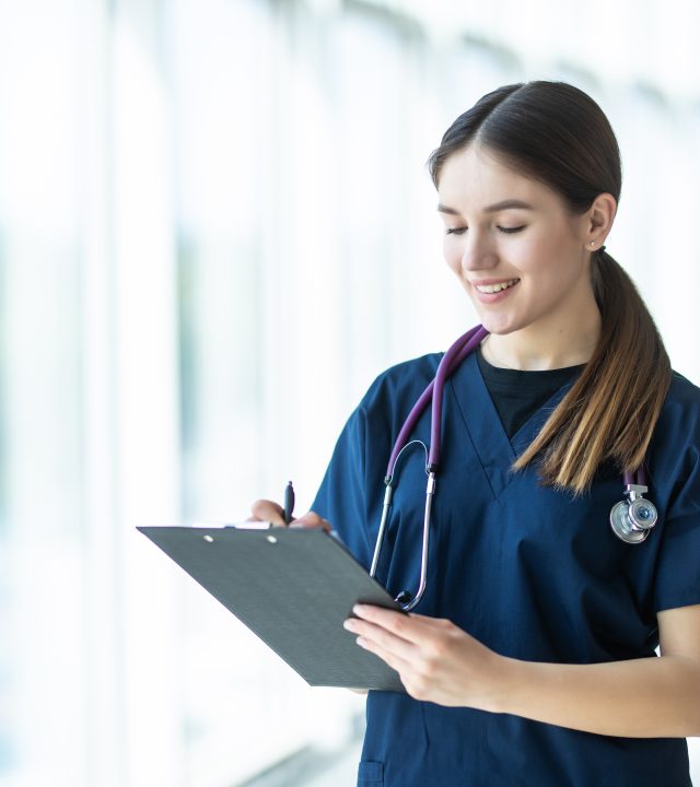 Smiling young female doctor holding a clipboard in hospital. healthcare concept